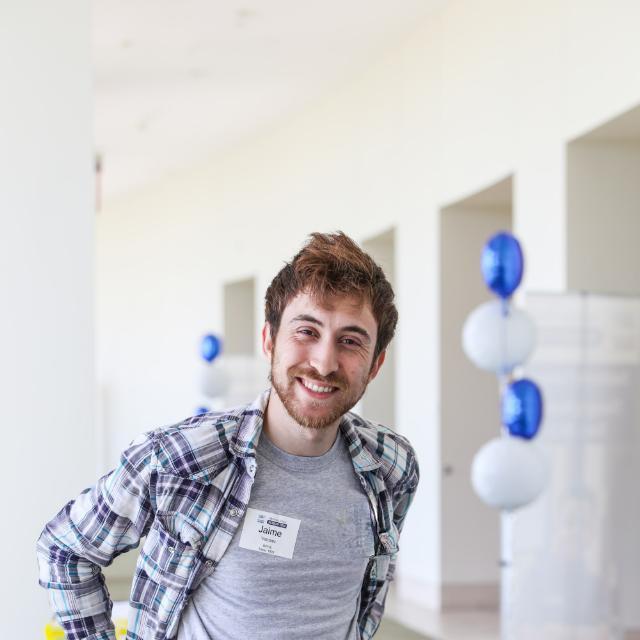 Jaime Vazquez, smiling, in a bright hallway with balloons in the background