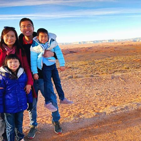 A family of four, Gabriel and Olivia and their two children, bundled up but in an arid landscape