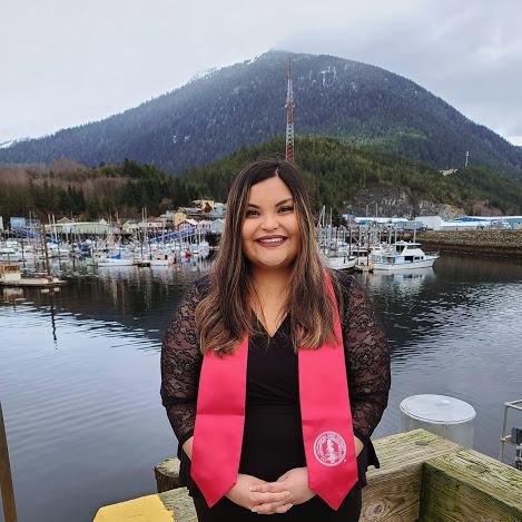 Photo of Jeanette Kaleikau-Buxton in Alaska, wearing her Stanford graduation stole