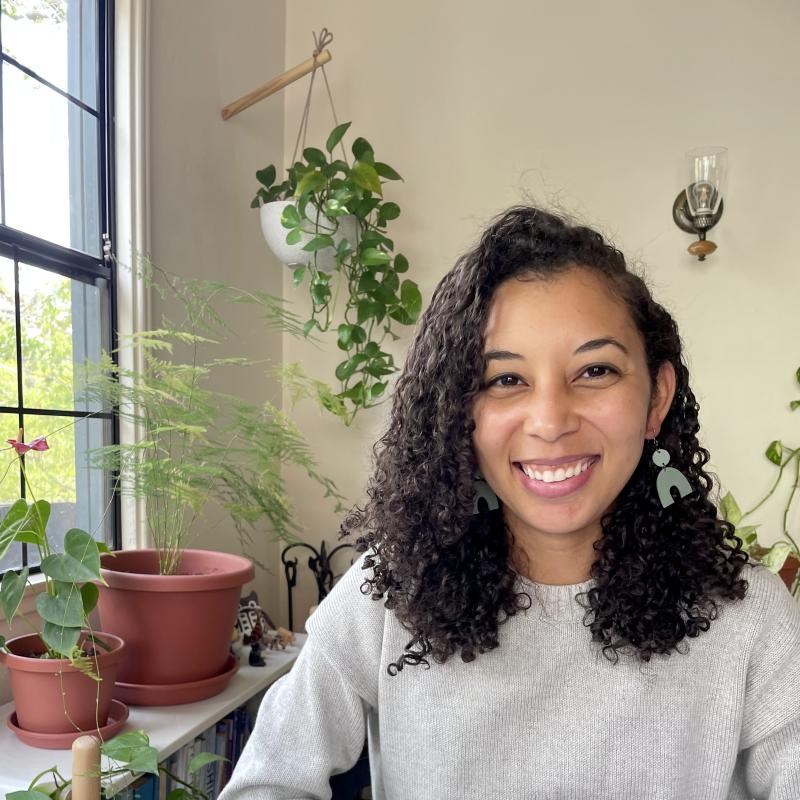 Laura Hinton in a room by a window with plants all around