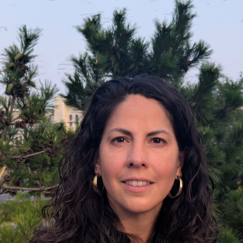 Photo of Marisol Castillo, outside with trees in the background, smiling and looking at the camera