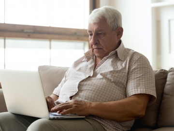 Photo of older man on a computer