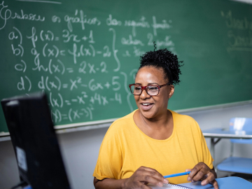 Photo of a teacher teaching online from a classroom