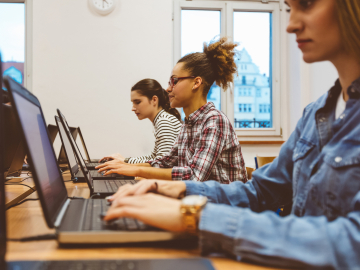 Students sitting in front of a laptop