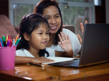 Photo of mother helping child with remote learning