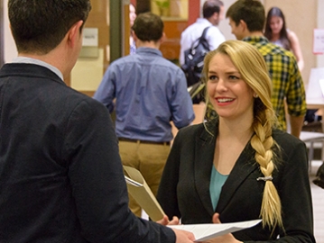 A GSE student (center) spoke with a potential employer on March 11 at a Stanford EdCareers job fair.