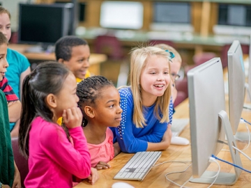 Children with computers in classroom (© Christopher Futcher, iStock)