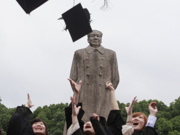 Graduates from Fudan University in Shanghai celebrate in front of the statue of late Chinese leader Mao Zedong on June 28, 2013.  Photo credit: Reuters