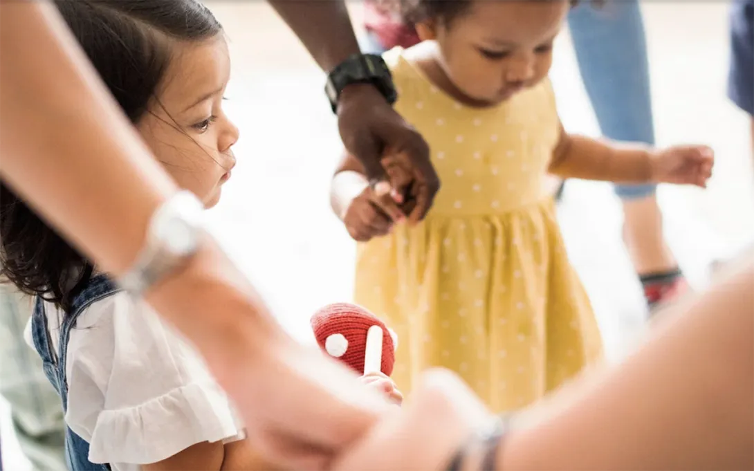 Picture of two little girls holding hands with adults