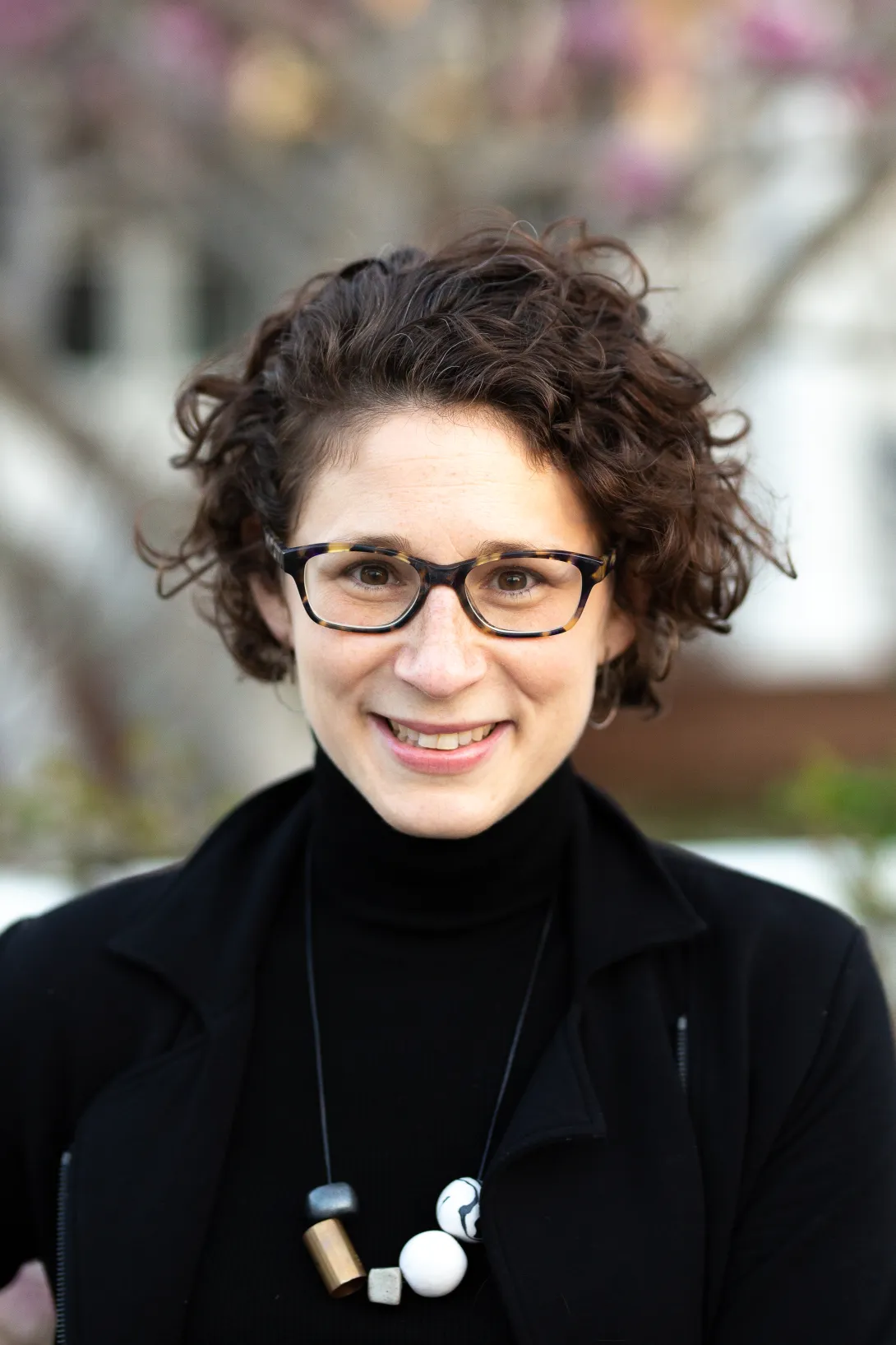 A photo graph of Emily J. Levine, dressed in black, outside in the winter